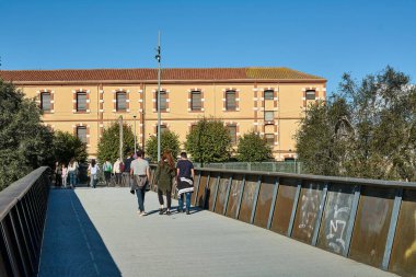 Montcada i Reixac. İspanya - 12 Kasım 2024: Moncada ve Reixac 'taki Ripoll nehrinden geçen manzaralı yaya köprüsü, insanların yürüdüğü ve suyun ve kentsel çevrenin manzarasının keyfini çıkardığı.