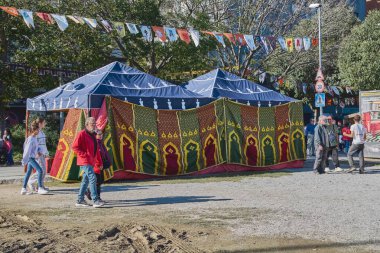 Montcada i Reixac. İspanya - 13 Kasım 2024: Bir açık hava festivalinde canlı ve renkli bir çadır kurulmuş, karmaşık desenlerle süslenmiş ve bayram afişleriyle çevrilmiş, kültürel kutlamaların özünü yansıtan.