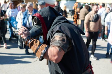 Montcada i Reixac. İspanya - 13 Kasım 2024: Canlı, renkli bir kostüm giymiş bir sokak sanatçısı kent festivali geçit törenine katıldı. Kostüm göz alıcı aksesuarlar ve dinamik bir poz içeriyor, canlı atmosferi yakalıyor..