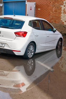 Viladecans. Spain - November 15,2024: Vehicles are seen in deep water on an urban road, submerged halfway up their wheels. The image emphasizes the effects of heavy rainfall and the challenges posed by sudden street flooding. clipart