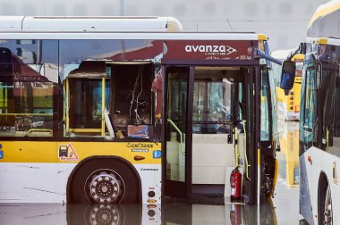 Viladecanlar. İspanya - 15 Kasım 2024: Otobüsler, tekerlerinin yarısına kadar batmış bir şehir yolunda derin sularda görülmektedir. Görüntü, şiddetli yağış ve ani sokak selinin yol açtığı zorlukların etkilerini vurguluyor.