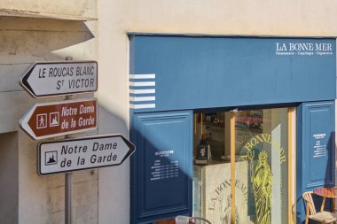 Viladecanlar. İspanya - 19 Kasım 2024: Marsilya 'da Notre Dame de la Garde ve Le Roucas Blanc' ın yönlü tabelalarının yer aldığı sokak sahnesi.