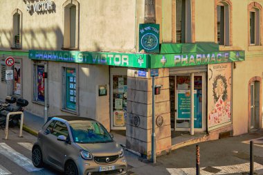 Marsilya. Fransa - 19 Kasım 2024: Marsilya 'daki bir eczanenin sokak manzarası, Pharmacie St. Victor tabelası, park edilmiş bir araba ve çevresindeki binaları gösteriyor. Kentsel ve ticari temalar için ideal.