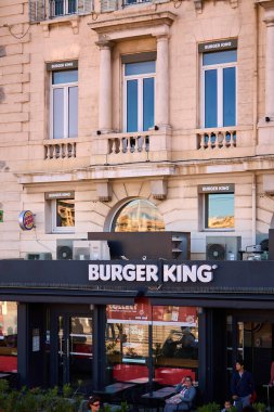 Marsilya. Fransa - 20 Kasım 2024: Marsilya 'nın Eski Limanı' nda yer alan Burger King restoranı, modern fast food markasıyla tarihi liman ortamını harmanlıyor. Görünür logolar ve tabela denizcilik arkaplanı arasında.
