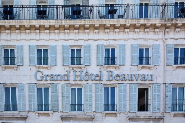 Marseille. France - November 20,2024: Facade of the Grand H tel Beauvau in Marseille, France, featuring blue shuttered windows and wrought iron balconies, highlighting its classic and elegant architectural design. clipart