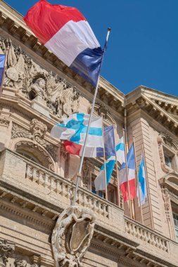 Marseille. France  - November 27,2024: Marseille city hall with French flags, showcasing the detailed facade and clear blue sky, perfect for themes of French heritage and government buildings. clipart