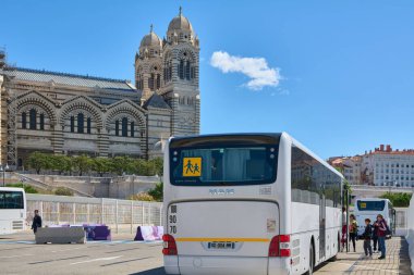 Marseille. France  - November 30, 2024:  School bus parked near marseille cathedral on a sunny day, with students getting on board clipart