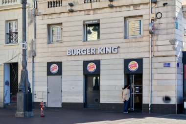 Marsilya. Fransa - Aralık 04, 2024: Bu fotoğraf eski bir taş binada yer alan Burger King 'in ana girişini gösteriyor. Tanımlanabilen tabela kapının üstünde, içeri giren bir kişi var, bu da restoranın aktif olduğunu gösteriyor..