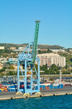 Marsilya. Fransa - 4 Aralık 2024: Görüntü, Marsilya limanında renkli nakliye konteynırları ve arka planda limanın endüstriyel önemini vurgulayan bir vinç yakaladı..