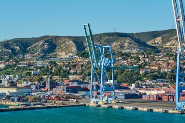 Marsilya. Fransa - 4 Aralık 2024: Görüntü, Marsilya limanında renkli nakliye konteynırları ve arka planda limanın endüstriyel önemini vurgulayan bir vinç yakaladı..