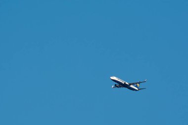 Marsilya, Fransa - 04 Aralık 2024: Açık mavi gökyüzüne karşı havada yakalanan bir Ryanair ticari jeti. Uçağın iniş takımları geri çekildi, bu da modern havacılık endüstrisini vurguluyor, yüksek irtifada uçtuğunu gösteriyor..