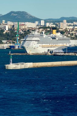 Marseille, France - December 05, 2024: Three large cruise ships docked side by side in Marseille harbor, against a backdrop of urban buildings and green hills, showcasing the city's vibrant port activity and scenic surroundings. clipart