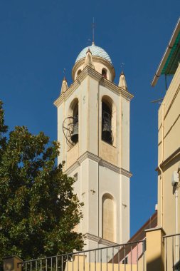 Albissola Marina 'daki Nostra Sinyora della Concordia Kilisesi' nin açık bir gökyüzü tarafından çerçevelenmiş kendine özgü kubbesi ve çanları ile tarihi çan kulesinin detaylı bir görüntüsü..