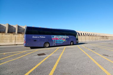 Civitavecchia, İtalya - 19 Aralık 2024: Pullman ve EUROBUS 'ta Crociere olarak işaretlenmiş mavi bir tur otobüsü sarı çizgilerle park edilmiş, ulaşım ve turizm sergilenmektedir.