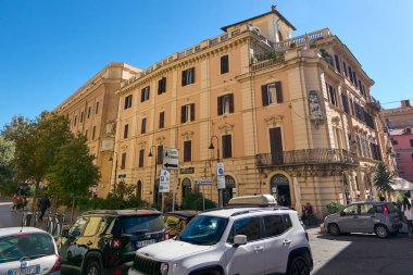 Civitavecchia. İtalya - 22 Aralık 2024: Civitavecchia, İtalya 'da Hotel De La Ville, büyüleyici mimari, günlük şehir hayatı ve park etmiş araç ve yayalarla dolu hareketli bir cadde sergileniyor.