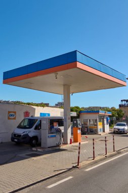 Civitavecchia. İtalya - 17 Aralık 2024: Civitavecchia 'daki birçok yakıt pompası ve ödeme terminali olan modern benzin istasyonu. Beyaz minibüs ve DKV işareti görünüyor. Kavram: Kentsel yakıt ikmali ve kolaylık.