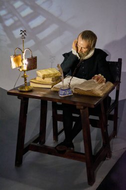 Madrid mi? İspanya - 14 Ocak 2025: Miguel de Cervantes 'in mum heykeli Madrid Balmumu Müzesi' ndeki ahşap bir masada oturuyordu. Tarihi ve edebi temalar için mükemmel