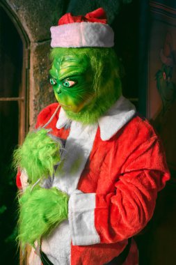 Madrid mi? İspanya - 16 Ocak 2025: Grinch 'in Noel Baba kostümü giymiş, yeşil kürklü ve yaramaz bir ifadesi olan balmumu heykeli Madrid Müzesi' nde sergileniyor..