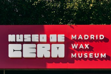 Madrid mi? İspanya - 16 Ocak 2025: Madrid Balmumu Müzesi hem İspanyolca hem de İngilizce yazı ile turistlerin ilgisini canlı kırmızı arka planda göstermektedir..