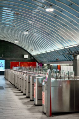 Madrid mi? İspanya - 17 Ocak 2025: Bir metro istasyonunda otomatikleştirilmiş kapılar ve bilet otomatları sırası, kentsel hareketlilik ve ulaşım teknolojisini vurguluyor.