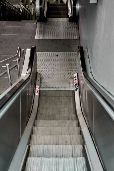 Urban scene of a modern escalator in a public transportation setting, highlighting steel and concrete materials