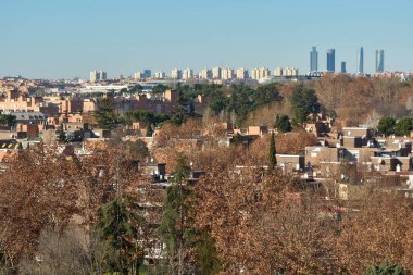 Madrid mi? İspanya - 19 Ocak 2025: Madrid 'de sonbahar kentsel gelişimi. Binalar, modern apartmanlar ve gökdelenler de dahil, önünde ağaçlar olan. Gayrimenkul ve şehir manzarası temaları için ideal.
