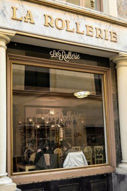 Madrid, İspanya - 21 Ocak 2025: Madrid 'deki La Rollerie cafe ve fırının manzarası büyük pencerelerden görünen sıcak ışıklandırma ve müşteriler rahatlatıcı bir an için mükemmel bir ortam yaratıyor.