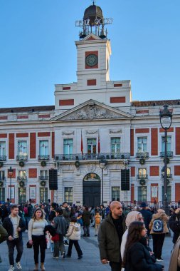 Madrid, İspanya - 22 Ocak 2025: Madrid Plaza Mayor 'u eğlenen insanlarla doludur. Şenlikli ışıklar ve dekorasyonlar tarihi meydanı süslüyor, canlı ve neşeli bir atmosfer yaratıyor..