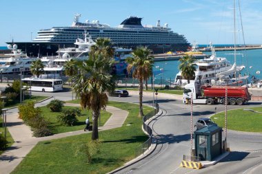 Civitavecchia. İtalya - 26 Ocak 2025: Civitavecchia limanı yolcu gemileri, yatlar ve araçlarla dolup taşıyor. Palmiye ağaçları ve açık gökyüzü manzaralı güzelliği artırıyor. Seyahatle ilgili içerik için mükemmel..