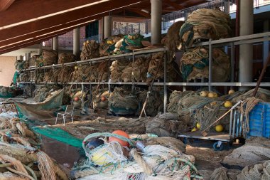 Traditional fishing nets stored in an open-air hangar. The fishing industry relies on these spaces for maintaining and preparing their essential equipment. clipart