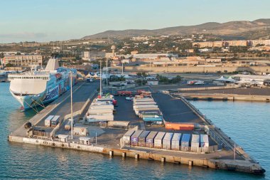 Civitavecchia, İtalya - 02 Şubat 2025: Lojistik, ticaret ve ulaşım ağlarını vurgulayan yoğun bir İtalyan limanında kamyonlar, konteynerler ve feribot. Konsept: sanayi, ticaret, lojistik, liman