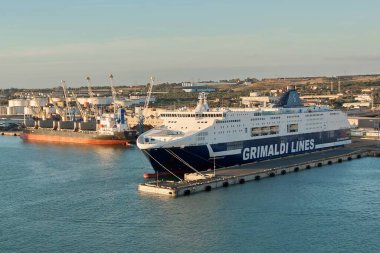 Civitavecchia, İtalya - 2 Şubat 2025: Limanı limanlı bir feribot ve sanayi kargo gemisi, deniz taşımacılığı ve uluslararası ticareti gösteriyor. Konsept: ekonomi, gemicilik, küresel ticaret.