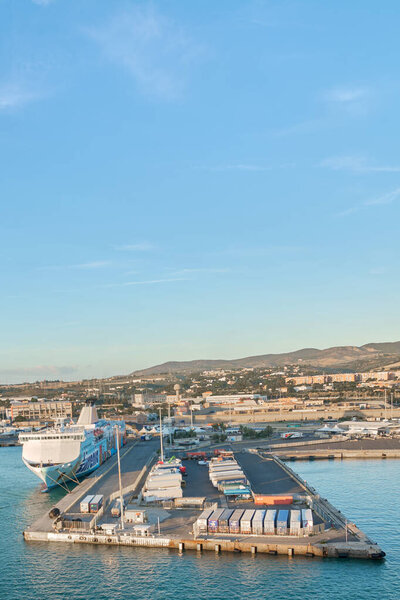 Чивитавеккья, Италия - 2 февраля 2025 года: Торговый паром, пристыкованный к порту, и морская логистическая инфраструктура. Концепция: коммерческий морской транспорт, логистика, транспортный узел.