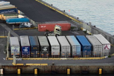 Civitavecchia. İtalya - 07 Şubat 2025: Küresel tedarik zinciri ve nakliye dağıtımını vurgulayan kargo konteynerlerinin yakınında bir kamyoneti olan lojistik merkezi. Taşımacılık endüstrisini kabul et