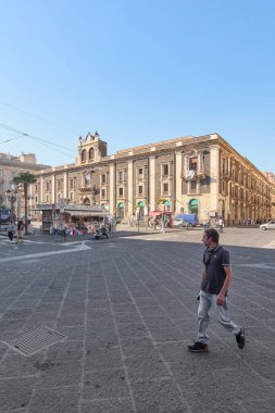 Catania. Italy - February 27, 2025: The majestic Palazzo Tezzano stands proudly in Catania bustling square. Ideal for travel photography, architectural heritage features, and urban lifestyle content clipart