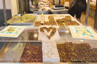 Catania. Italy - March 03, 2025: This image features a tempting array of pistachio sweets and traditional Sicilian desserts in a bustling Catania market. Ideal for culinary websites tourism promotions clipart