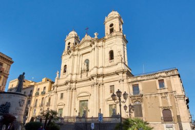 Catania 'da. İtalya - 03 Mart 2025: Assisi 'nin Aziz Francis heykeli ve barok bir kilisenin ayrıntılı dış cephesi de dahil olmak üzere dini sembolizm içeren Avrupa kentsel simgesi.