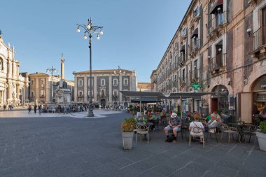 Catania 'da. İtalya - 4 Mart 2025: Sicilya, Catania 'da Piazza del Duomo, canlı açık hava yemekleri, barok mimarisi ve görkemli bir Akdeniz atmosferi yaratıyor..