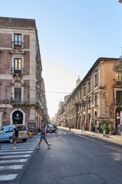 Catania 'da. İtalya - 04 Mart 2025: Catania, Sicilya 'da yayalar, tarihi mimari ve açık gökyüzünün yer aldığı hareketli bir sokak manzarası.
