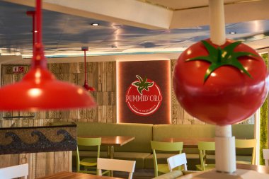 Catania 'da. İtalya - 08 Mart 2025: Canlı yeşil sandalyeler, ahşap masalar, kırmızı lambalar ve sıradan bir yemek deneyimi için mükemmel bir ortam sunan rahat pizzacı.