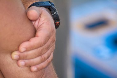 İki tane mısır çuvalı tutan ve onları güneşli bir açık havaya atmaya hazır bir adamın yakın çekimi. Resim, oyuncunun beklenti ve odak noktasını yakalar