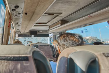 Catania 'da. İtalya - 27 Mart 2025: Konforlu koltuklar, görünür yolcular ve ilerlerken pencerelerden yansıyan yansımalar içeren tur otobüsü.