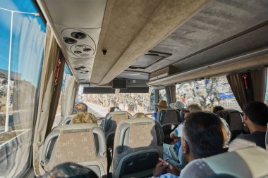 Catania 'da. İtalya - 27 Mart 2025: Yansımalar, tavan yapıları ve temiz pencerelerden içeri akan ışık arasında rahat bir şekilde oturan seyahat otobüsünün içerisini yakalamak.