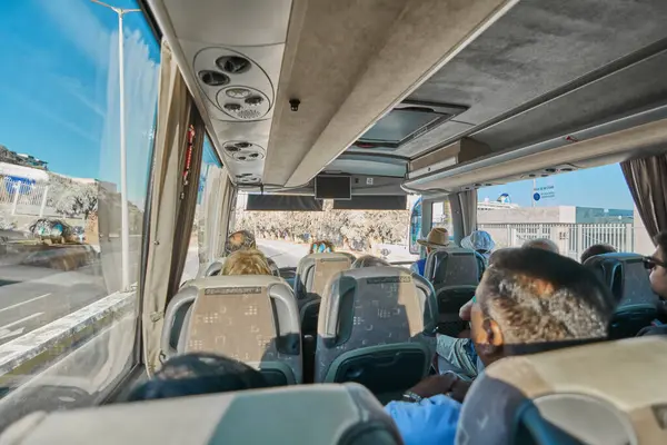 Catania 'da. İtalya - 27 Mart 2025: Bir otobüsün içindeki odaklanmış manzara, düzenli bir sırada oturan yolcuları ve yan camlardan yansıyan ışık ile iç tavanı gösteriyor.