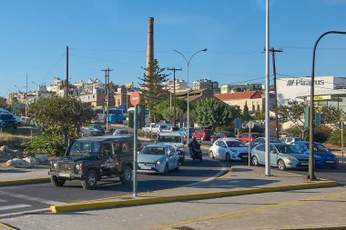 Girit. - Yunanistan - 27 Mart 2025: Girit, Yunanistan 'da kalabalık bir cadde, Safari Kulübü etiketli bir off-road aracı güneşli mavi gökyüzü altında arabaların ve motosikletlerin yanına park edilmiş..