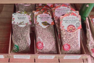 Girit. Yunanistan - Nisan 03, 2025: Yunanca ve İngilizce etiketli balık ve geleneksel Yunan yemekleri de dahil olmak üzere paketlenmiş bitki ve baharat seçimi aşçılık meraklıları için sergilendi.