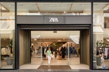 Girit, Yunanistan - 7 Nisan 2025: Parlak cam fay ve minimalist tasarıma sahip modern bir Zara mağazası, hareketli kentsel alışveriş alanında modaya uygun giyinmiş vitrin mankenleri sergiliyor.