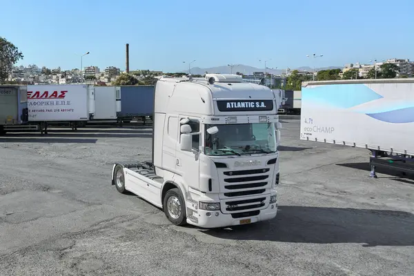 Girit, Yunanistan - 7 Nisan 2025: Bu resim, yoğun bir lojistik bölgede konuşlanmış parlak beyaz bir kamyon traktörünü çekiyor. Pratik tasarımı ve sağlam yapısı güvenilir taşıma işlevlerini sağlar.