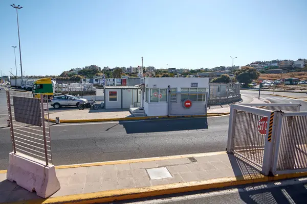 Girit, Yunanistan - 7 Nisan 2025: Açık tabelalı ve engelli organize park alanı. Sahil konumu, yakındaki bir yolcu gemisinin demirlediği ve kentsel faaliyetin görülebildiği canlı çevreyi de kapsıyor..