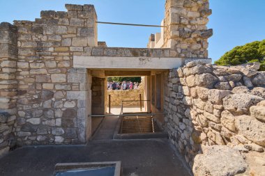 Girit. Yunanistan - 05 Mayıs 2025: Turistler Knossos Sarayı 'nın yıpranmış taş yapılarından geçerek Girit' in en önemli arkeolojik alanlarından birinde Minos tarihinin kalıntılarını araştırıyorlar..